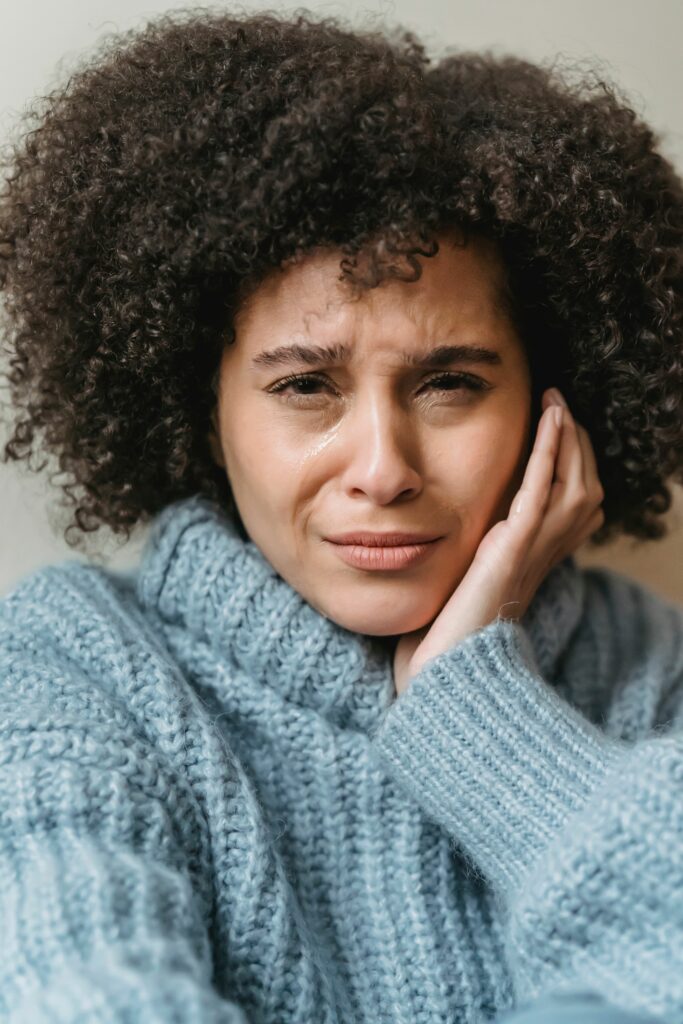 femme se tenant la joue à cause d'une douleur dentaire